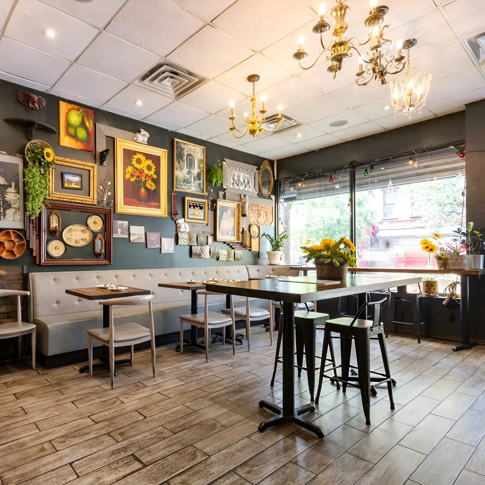 Link Thai restaurant interior with eclectic wall decor, wooden tables, and gray booth seating.